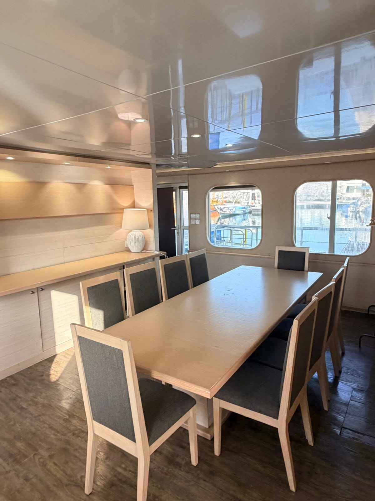 Indoor dining room with a long wooden table, upholstered chairs and a sideboard