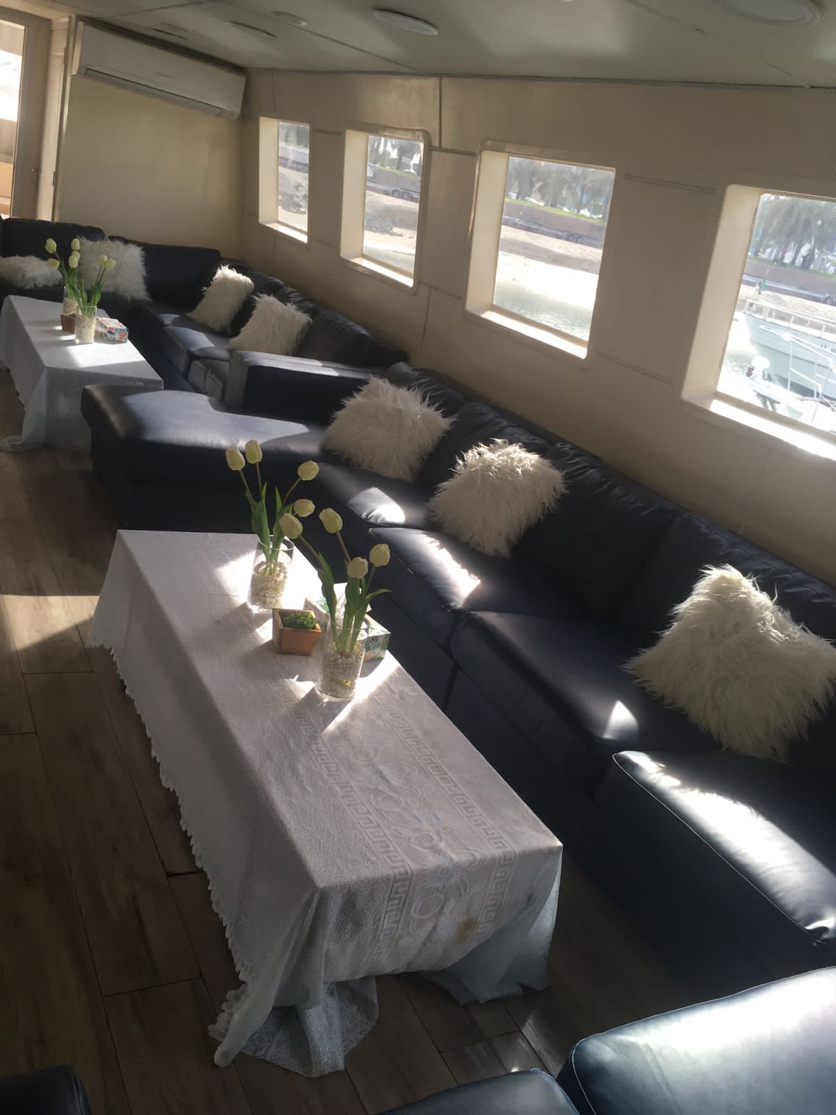 Lounge sofas decorated with white cushions and tulip centrepieces for an event