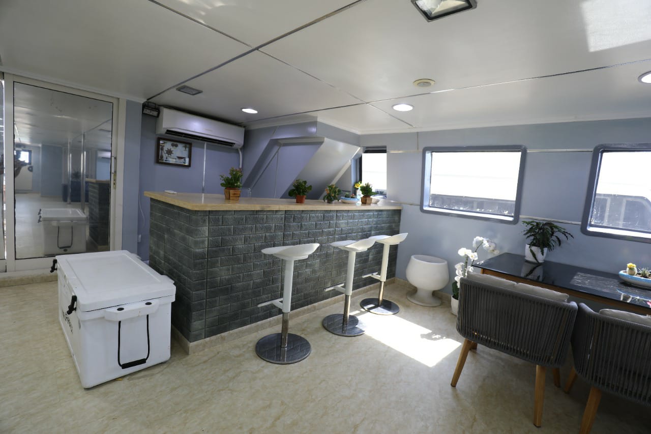 Indoor bar counter with stools and a dining table beside the windows