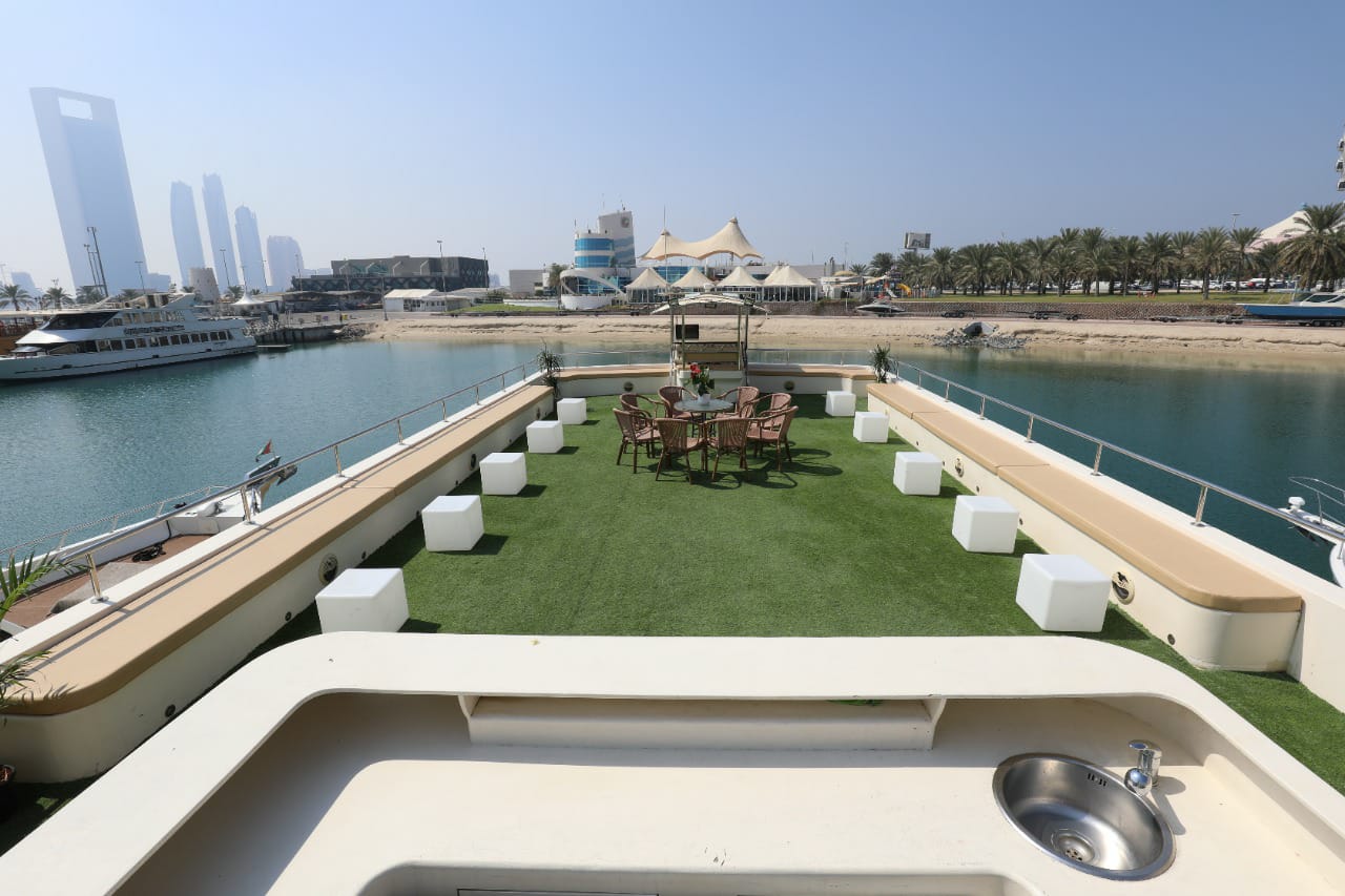 Wide view of the spacious open upper deck with bench seating and the Abu Dhabi skyline
