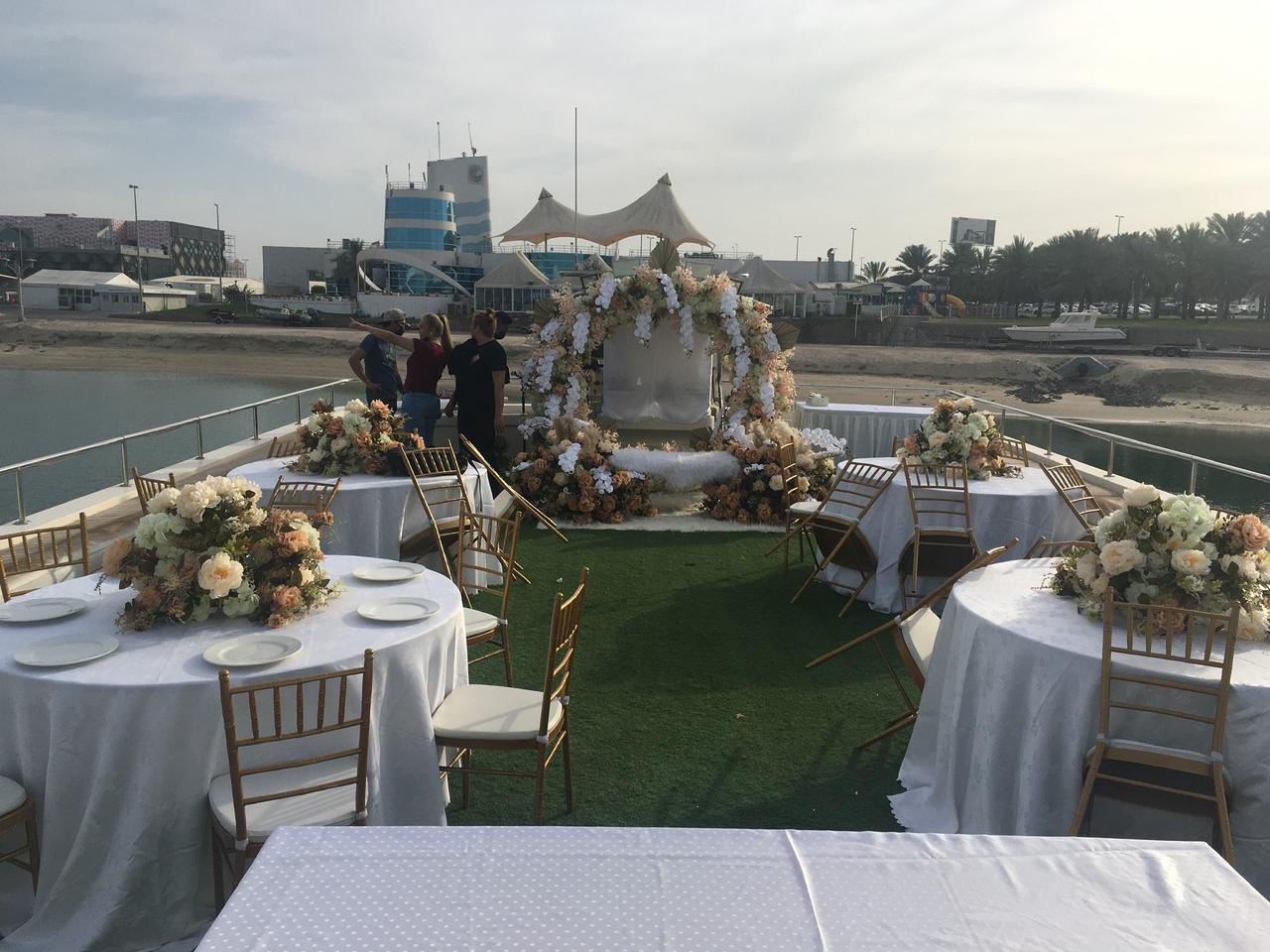 Wedding setup on the upper deck with a floral arch and round dining tables