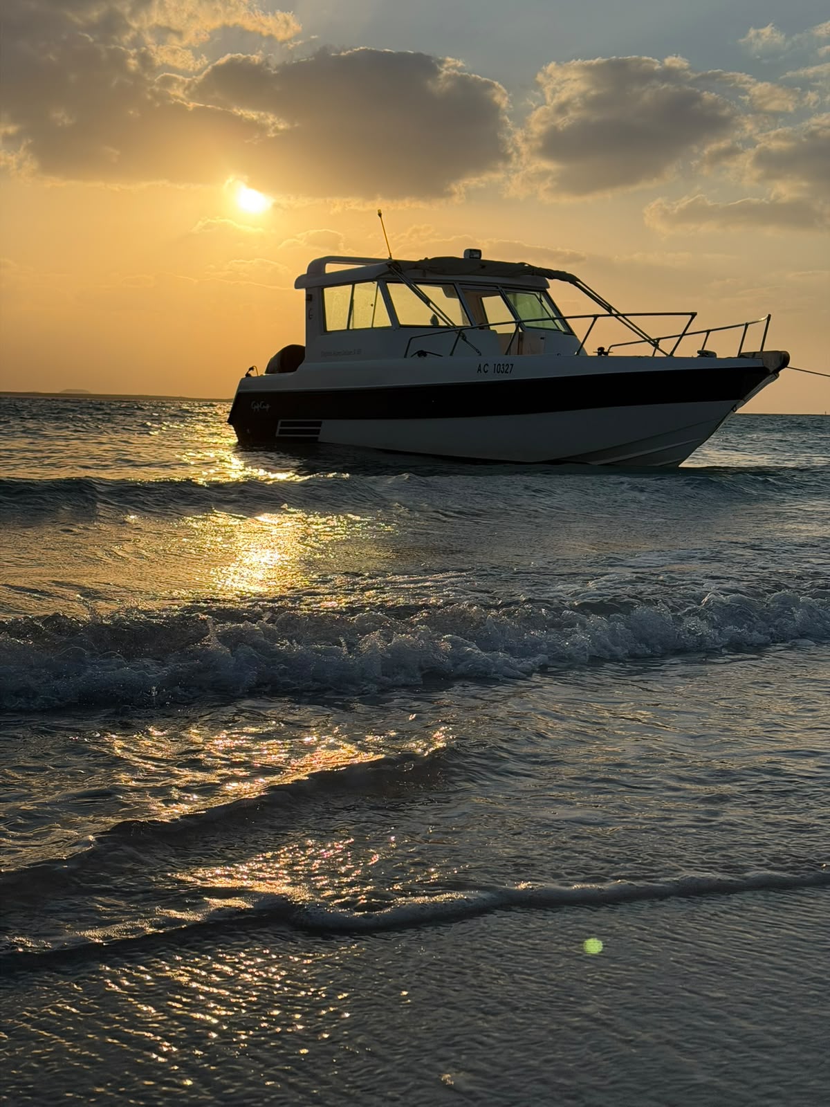 Waves rolling in front of the 33 ft boat under a golden sunset
