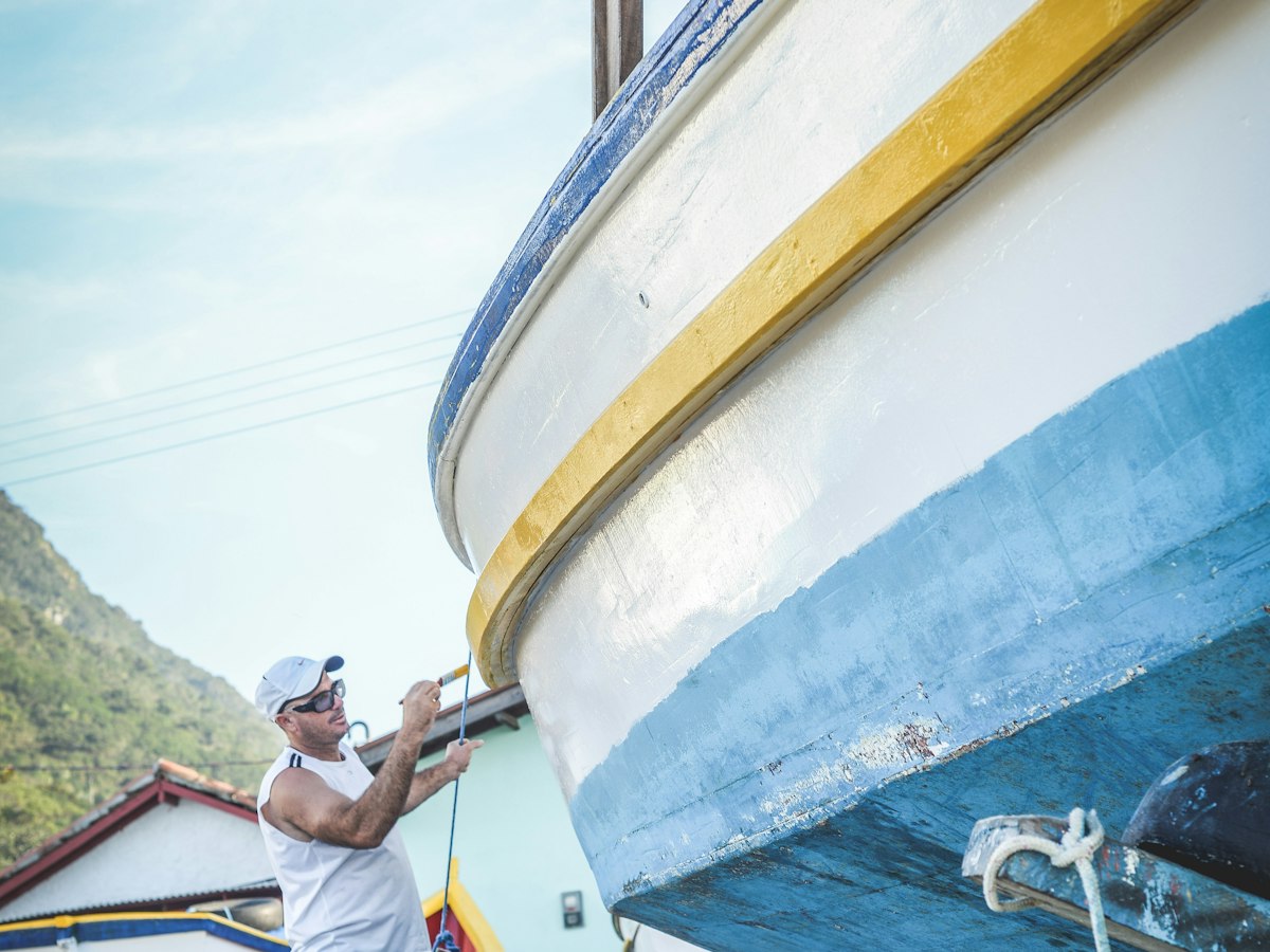 Painter working on a boat hull